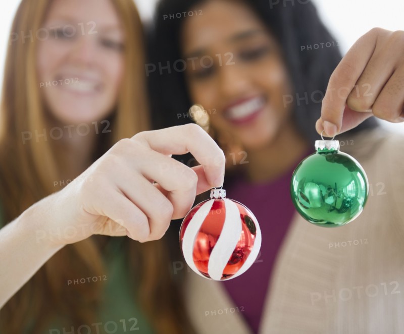 Friends holding small Christmas ornaments