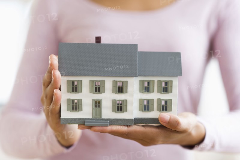 Hispanic woman holding miniature house