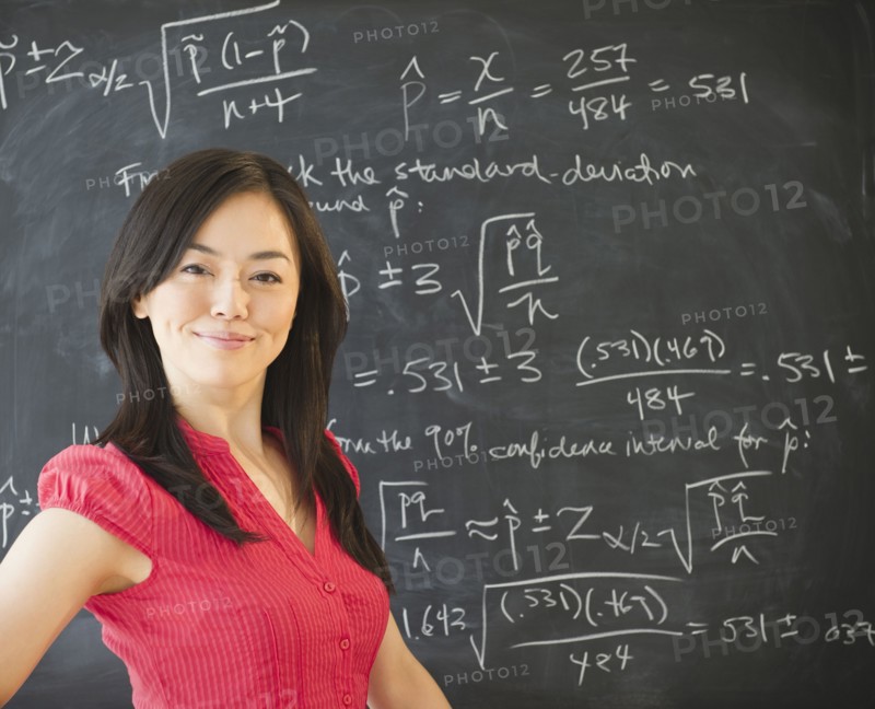 Japanese teacher standing near blackboard