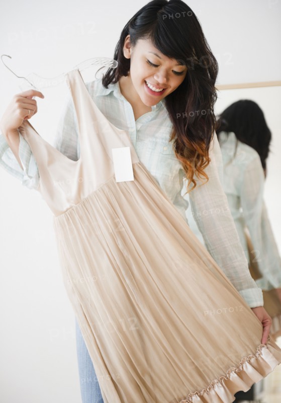 Pacific Islander woman looking at dress in store