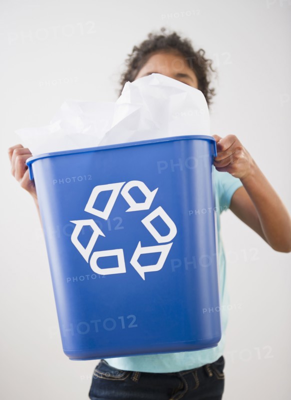 Mixed race girl carrying recycling bin