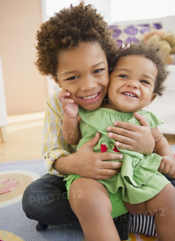Black brother holding sister on his lap