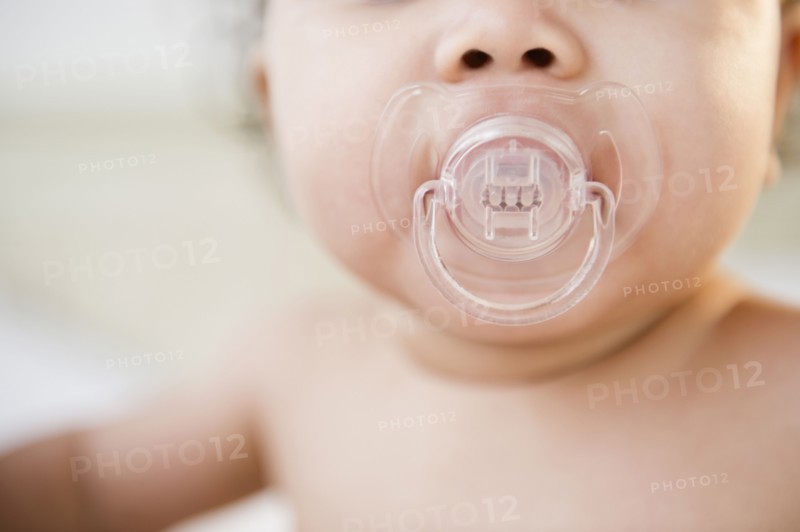 Mixed race baby sucking pacifier