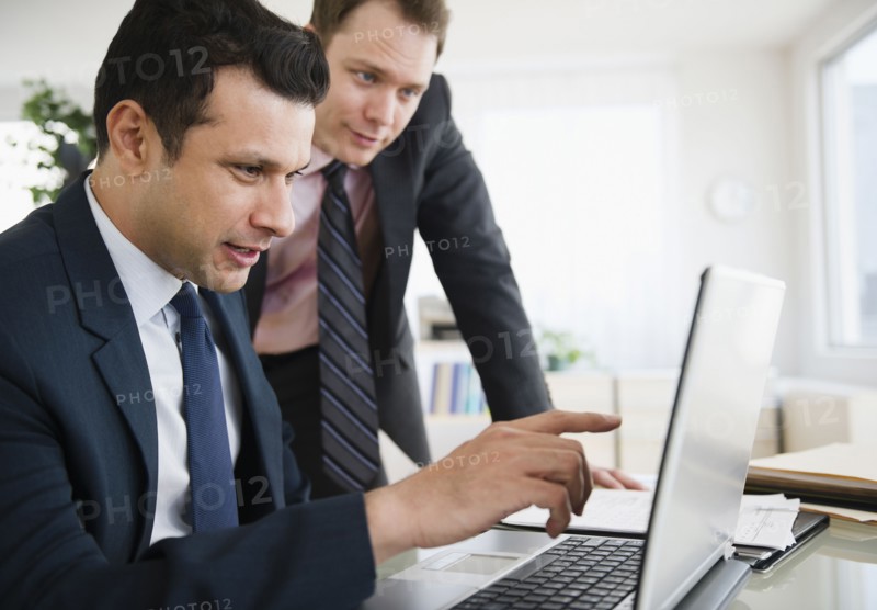 Businessmen working together on laptop
