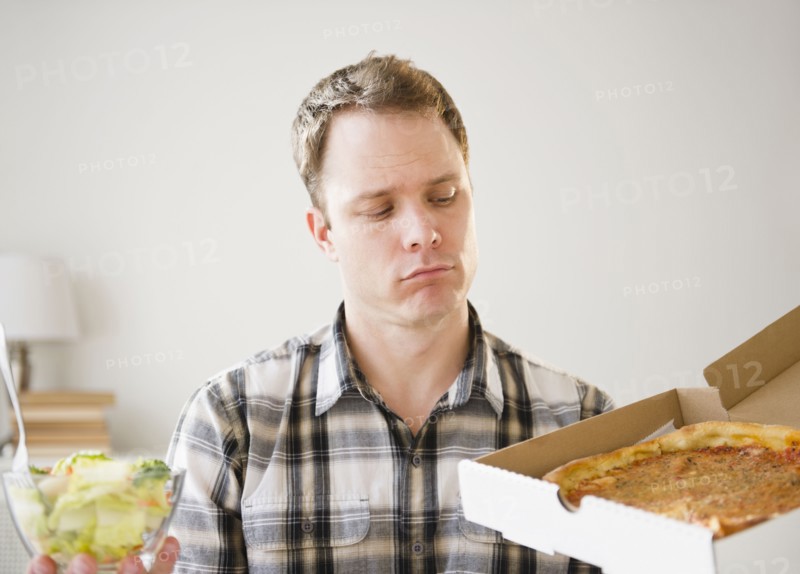 Caucasian man looking at pizza in box