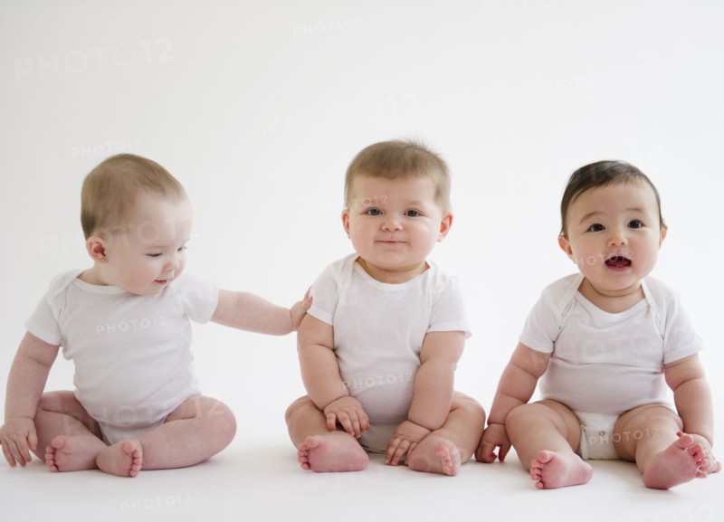 Three babies sitting on floor