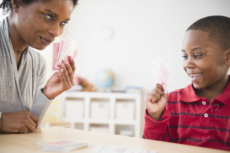 Black mother and son playing cards together
