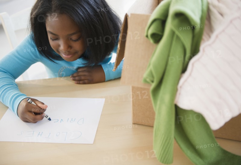 Black girl donating clothing to charity