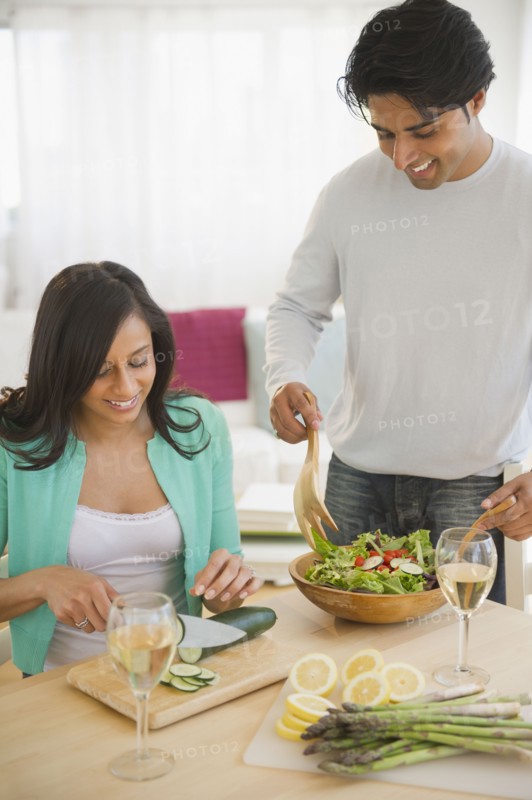 Mixed race couple preparing salad