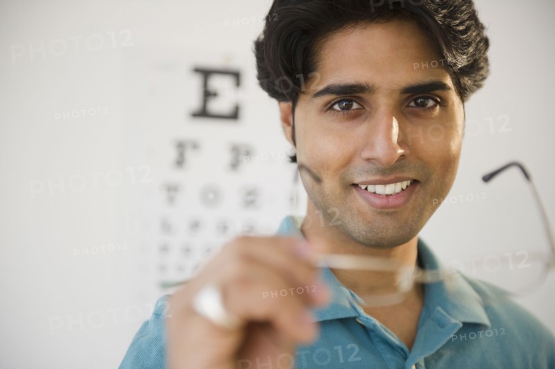 Mixed race man taking of eyeglasses