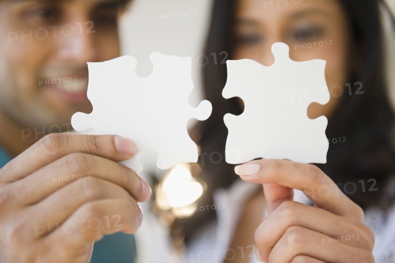 Mixed race couple holding puzzle pieces