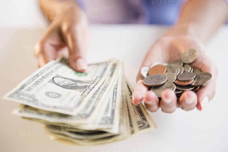 Cape Verdean woman holding dollar bills and coins