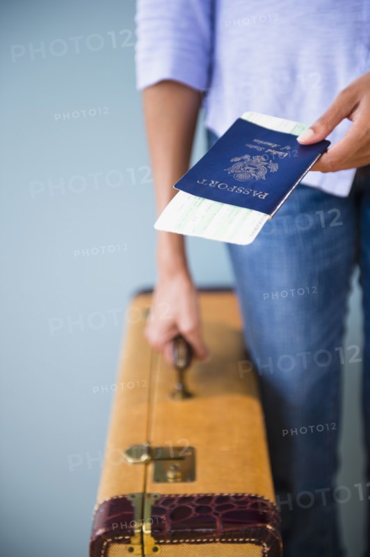 Cape Verdean woman holding passport and suitcase