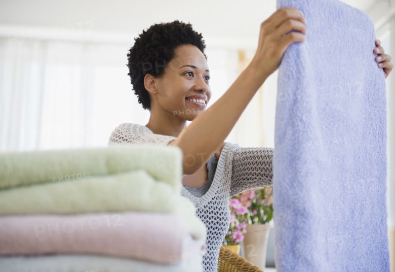African American woman folding towels