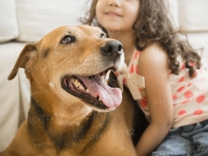 Mixed race girl sitting with dog