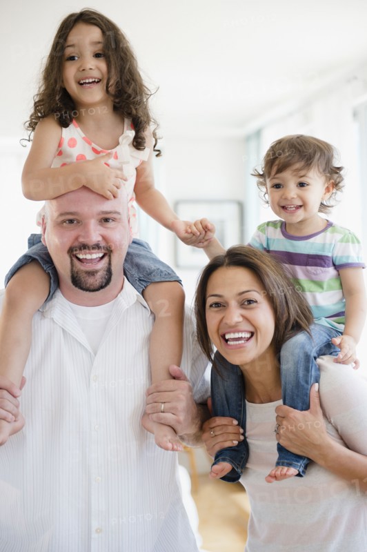 Parents carrying children on shoulders