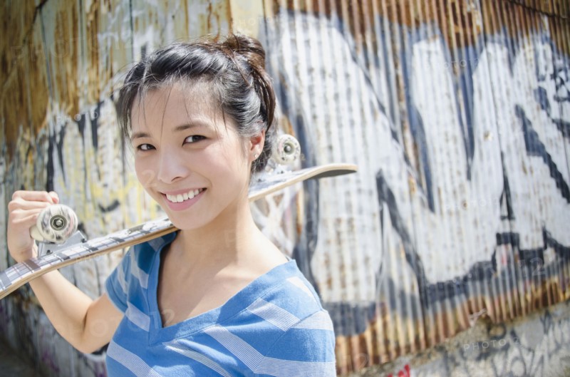 Asian woman carrying skateboard