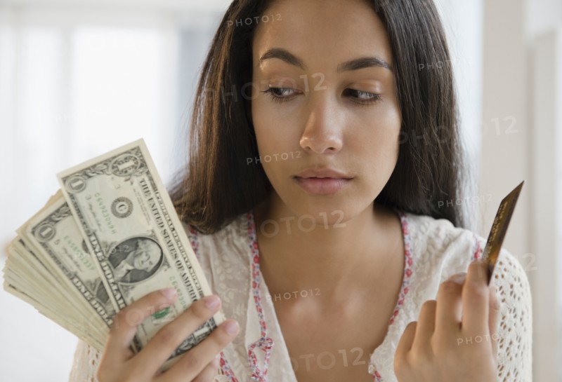 Hispanic teenager holding credit cards and money