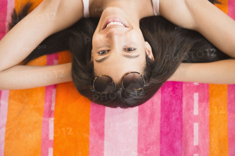 Hispanic teenager laying on towel