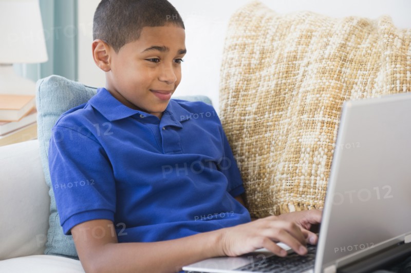 Hispanic boy typing on laptop