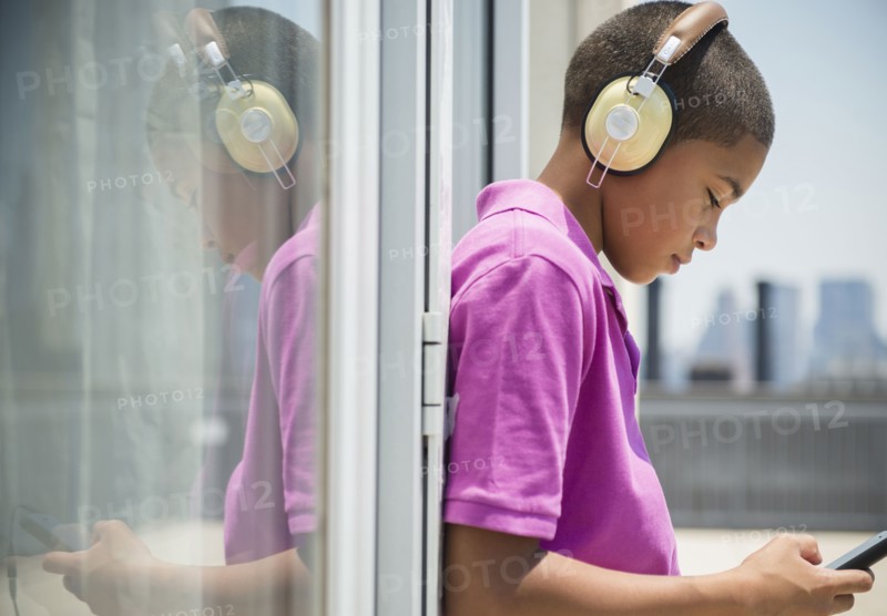 Hispanic boy listening to music on headphones