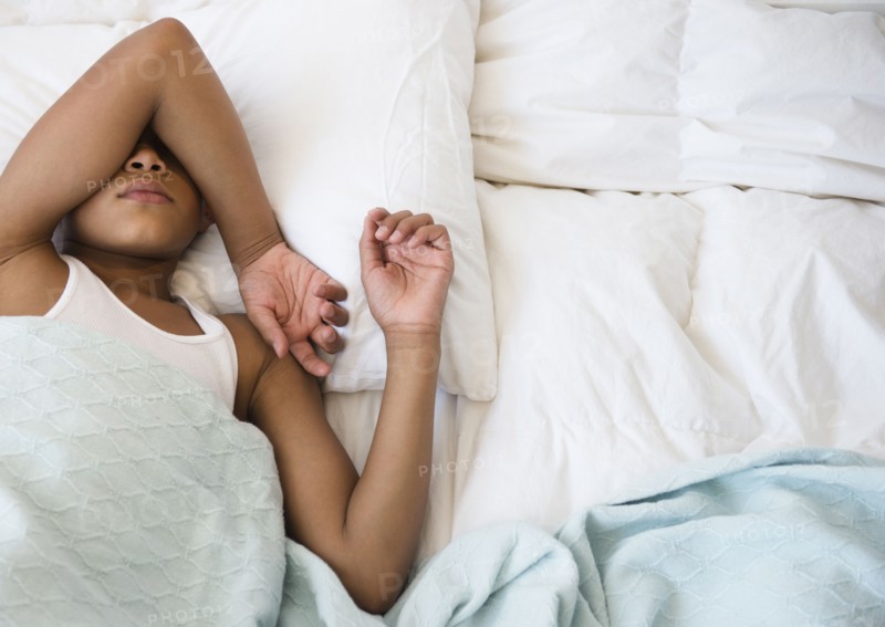 Hispanic boy laying in bed