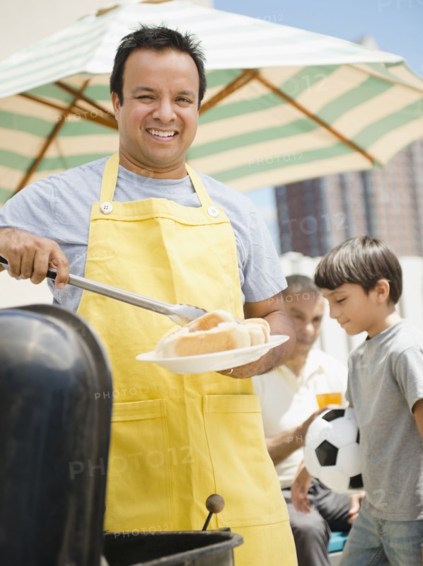 Hispanic father and son at barbecue