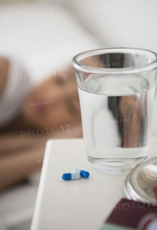 Close up of pills and water on bedside table