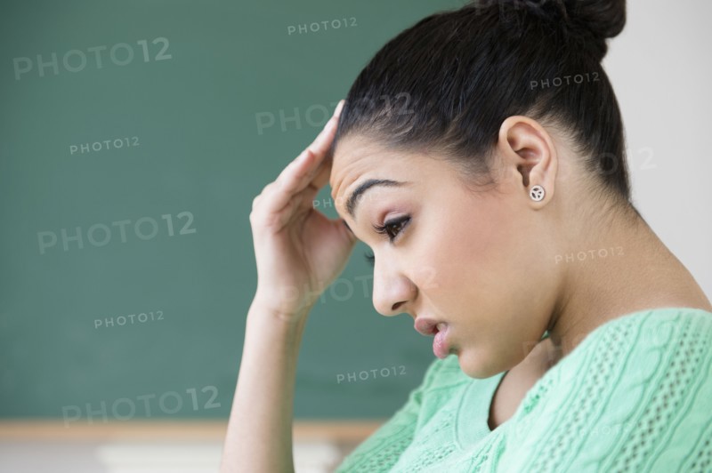Hispanic woman rubbing forehead