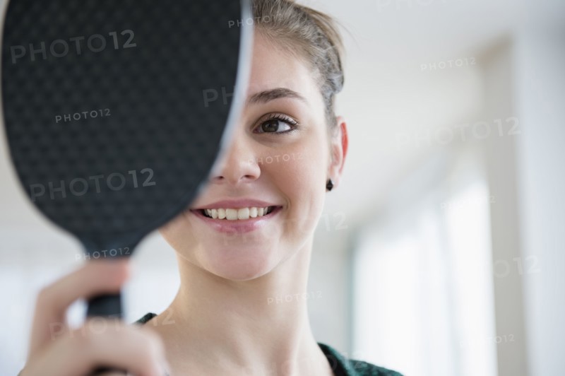 Hispanic girl admiring herself in mirror