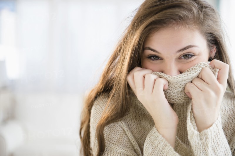 Hispanic girl covering her face with sweater