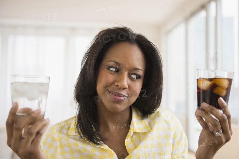 African American woman choosing water or soda