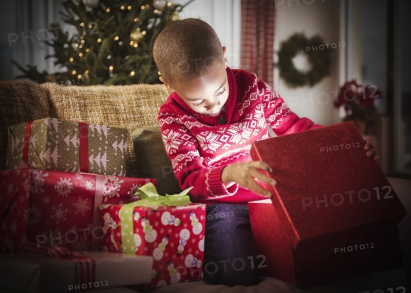African American boy opening Christmas presents
