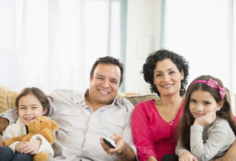 Family watching television together on sofa