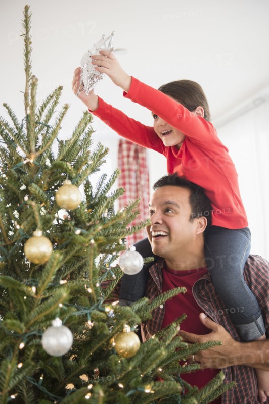 Father and daughter decorating Christmas tree