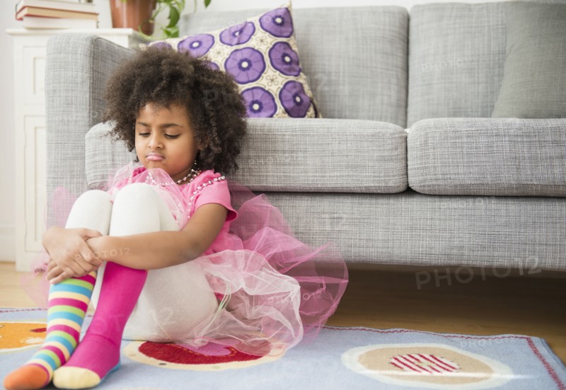 African American girl frowning in living room