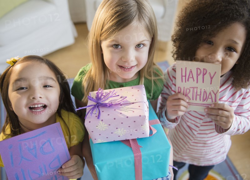 Girls holding presents and cards at birthday party