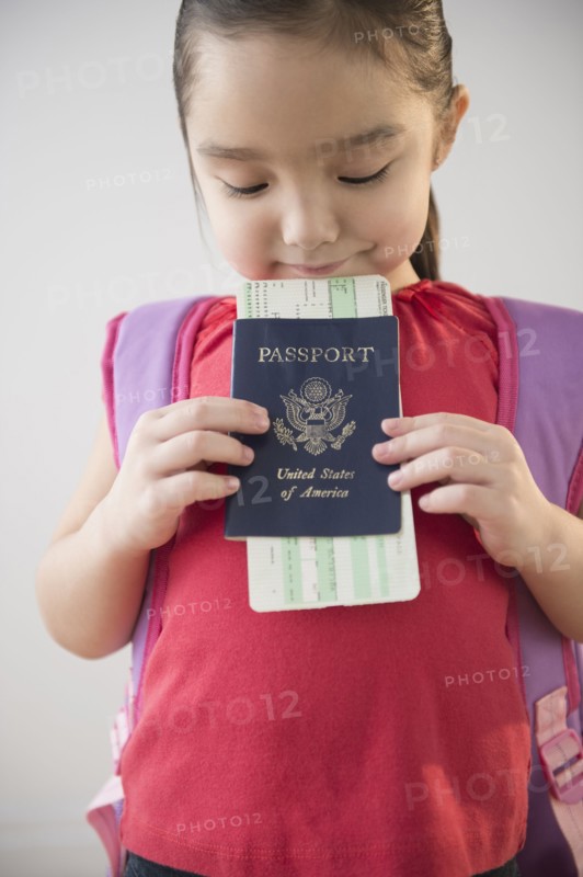Asian girl holding airplane ticket and passport
