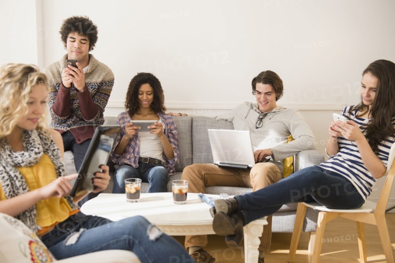Friends using technology in living room