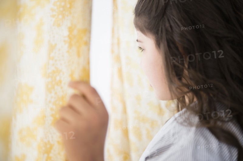 Hispanic girl looking out window