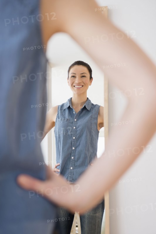 Caucasian woman admiring herself in mirror