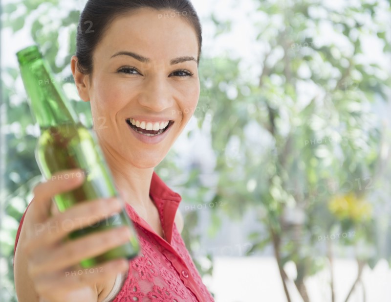 Caucasian woman holding bottle of beer