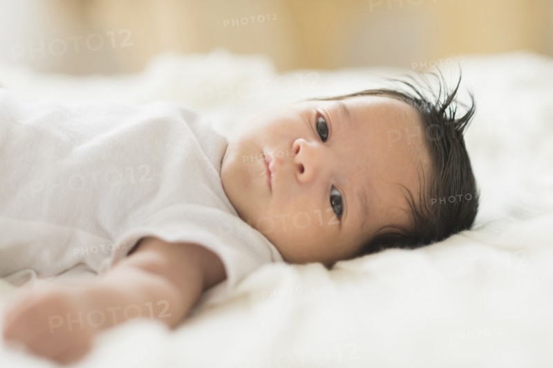 Hispanic infant laying on blanket