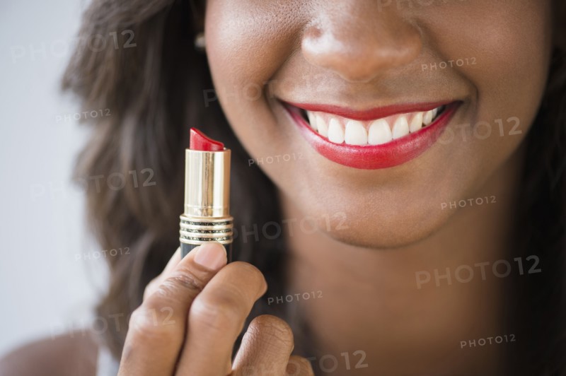 Black woman holding lipstick