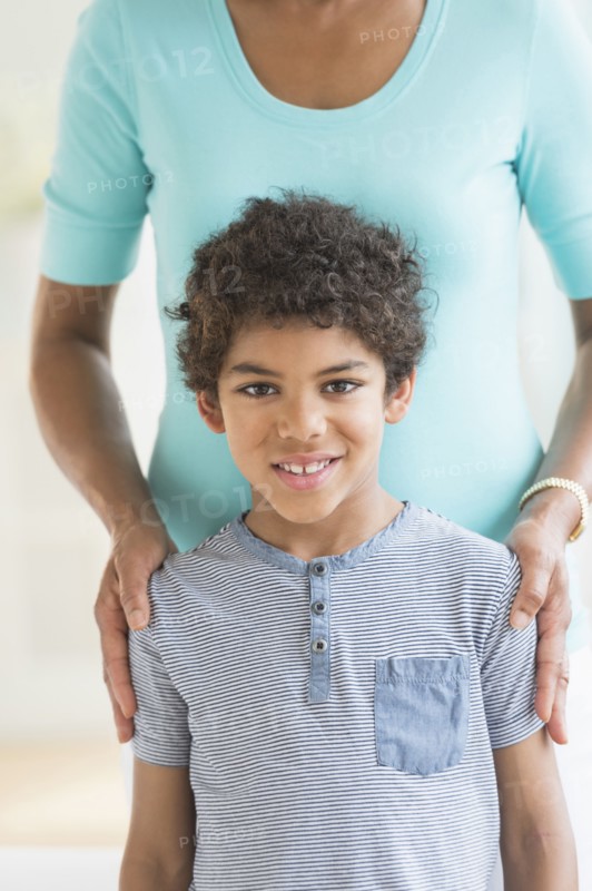 Smiling boy standing with mother