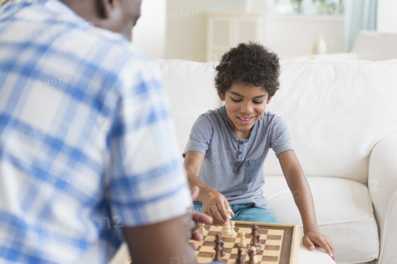 Boy playing chess with grandfather