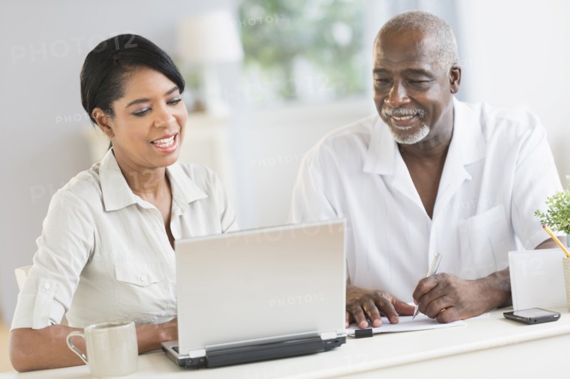 Black father and daughter using laptop