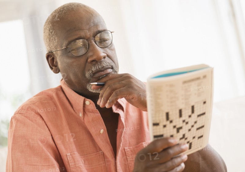 Black man doing crossword puzzle