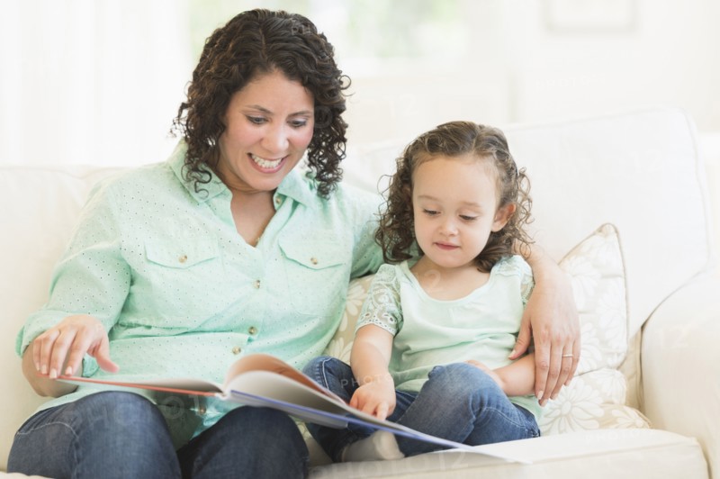 Mixed race mother reading with daughter