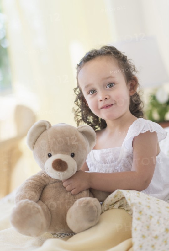 Mixed race girl holding teddy bear